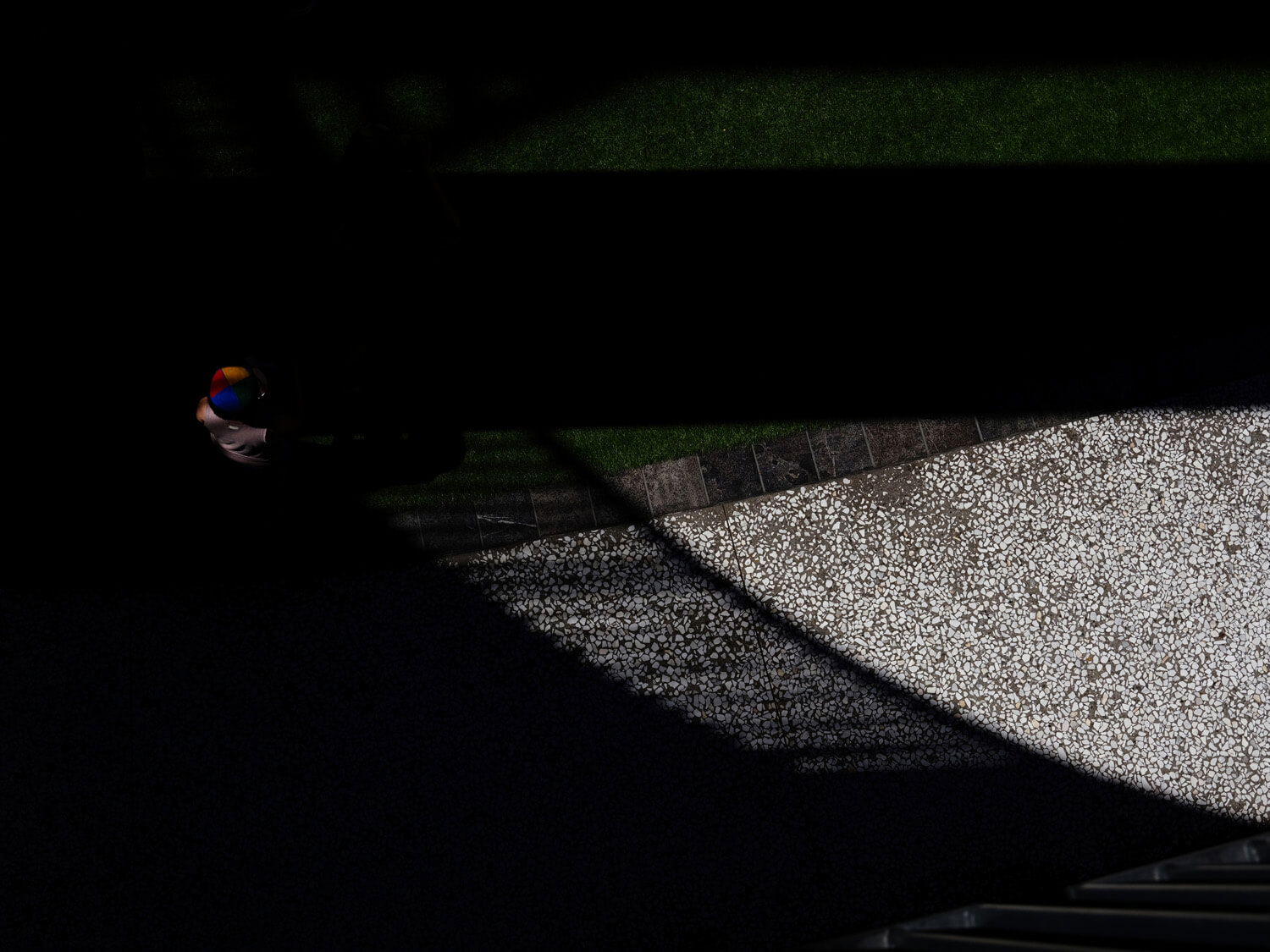Person in colorful clothes standing in shadow with diamond light ray ahead