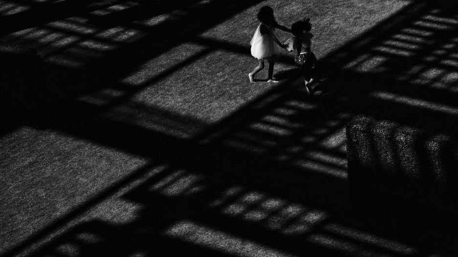 Two young girls playing in crossed shadows