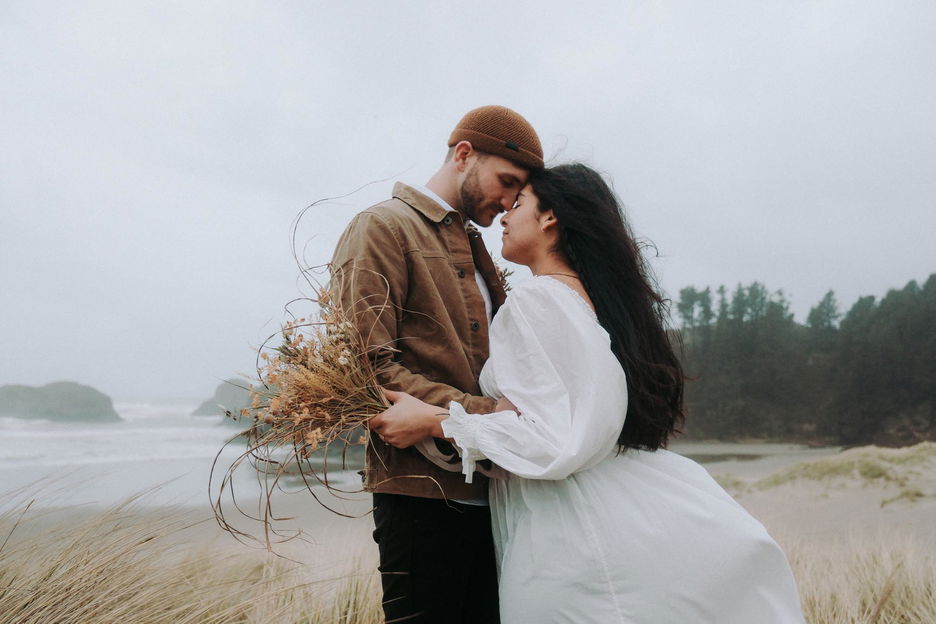 A couple embrace along the sandy shores of Portland, Oregon