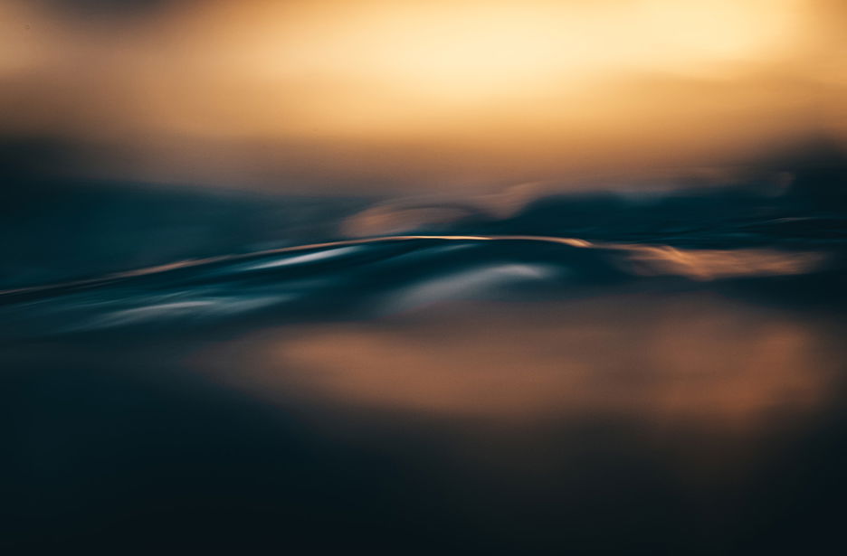 Close up fine art photograph of waves on the ocean's surface at sunset