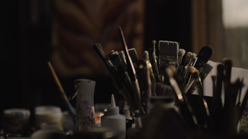 Videographer, Giulio Meliani uses FUJINON XF50mmF1.0 R WR to profile legally-blind artist, Therese Verner and show the importance of art. Image shows a video still of a pot of paintbrushes.