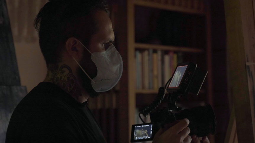 Videographer, Giulio Meliani uses FUJINON XF50mmF1.0 R WR to profile legally-blind artist, Therese Verner and show the importance of art. Image shows a profile photograph of Giulio Meliani filming handheld wearing a facemask due to the Covid-19 pandemic.