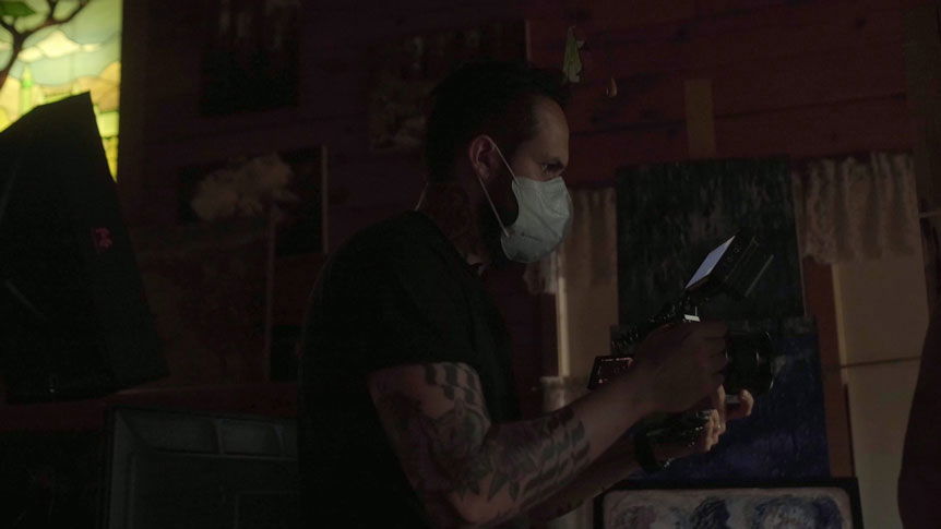Videographer, Giulio Meliani uses FUJINON XF50mmF1.0 R WR to profile legally-blind artist, Therese Verner and show the importance of art. Image shows a profile photograph of Giulio Meliani filming handheld wearing a facemask due to the Covid-19 pandemic.
