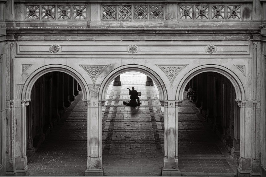 Wedding photographer, Petronella Lugemwa tests FUJIFILM X-S10. Image shows a street musician playing in the Bethesda Terrace Arcade, silhoutedded against the light reflecting on the stone floor.