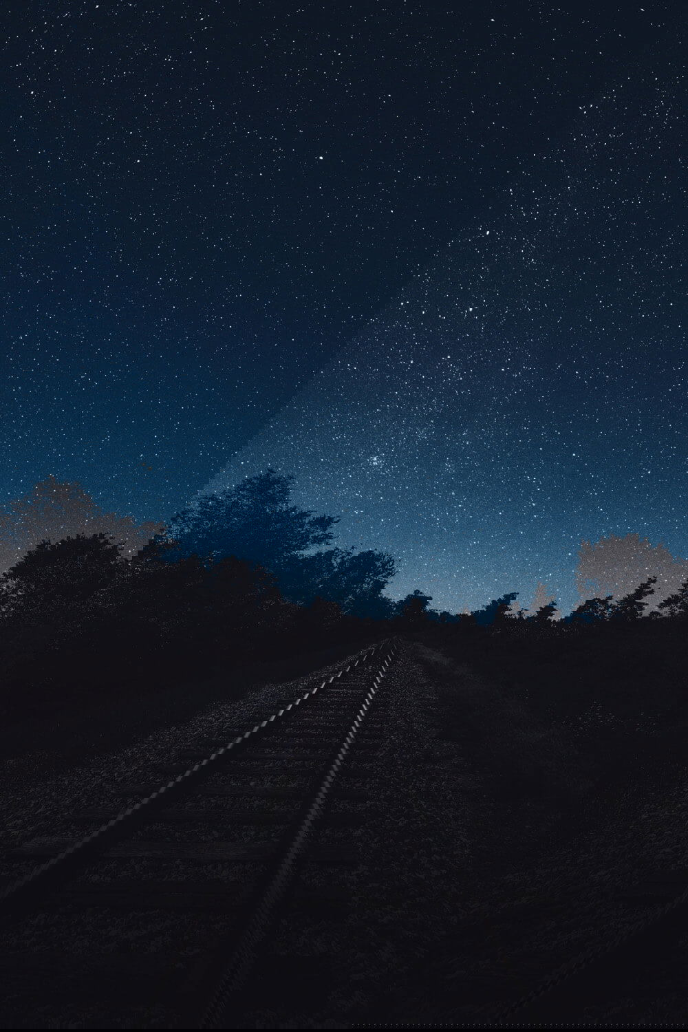 FUJIFILM Creators talk about how a lend can affect your message. Briyan Minear's image of the night sky filled with stars above an empty railway line. that stretches into the distance.