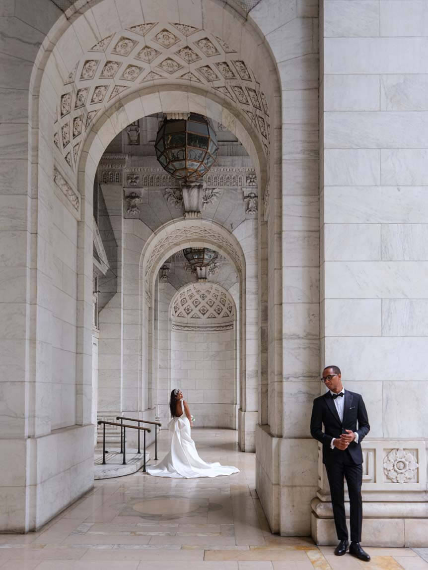 Bride and groom standing beneath high archway