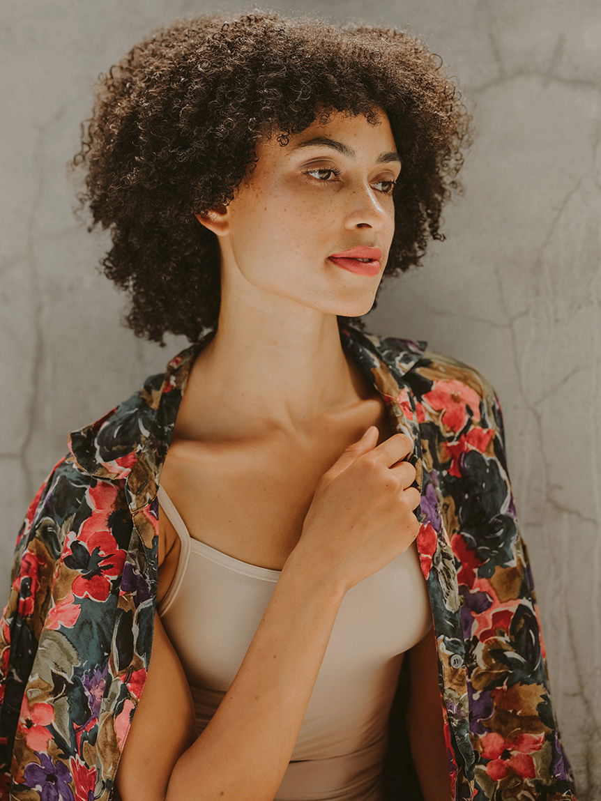 Young, dark-haired woman wearing red lipstick and a floral jacket