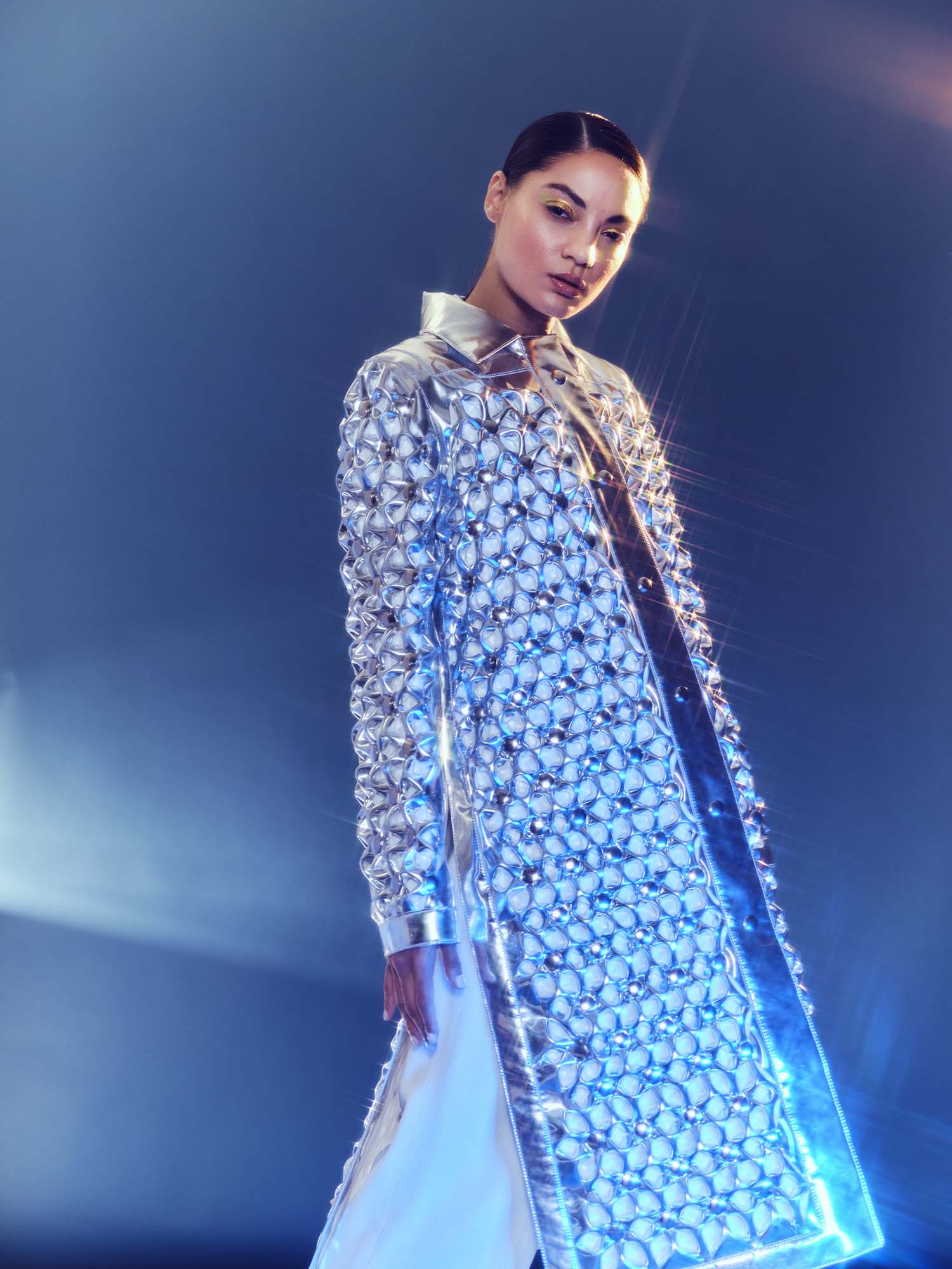 Model in silver jacket glistening in light