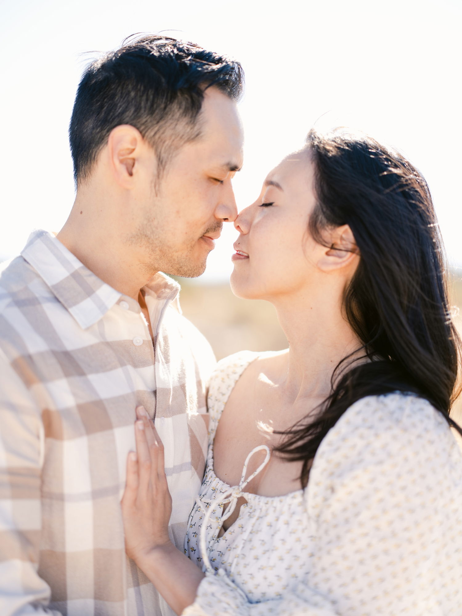 An Asian couple embrace, eyes closed