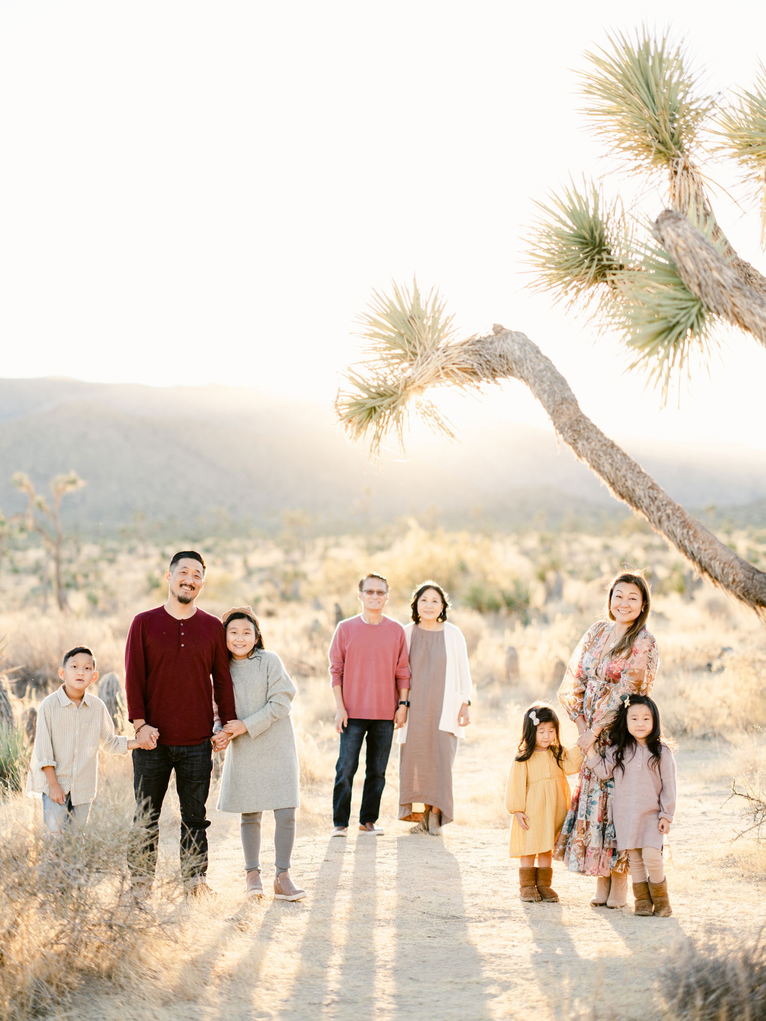 An extended Asian family poses for a photo in a sprawling park locale