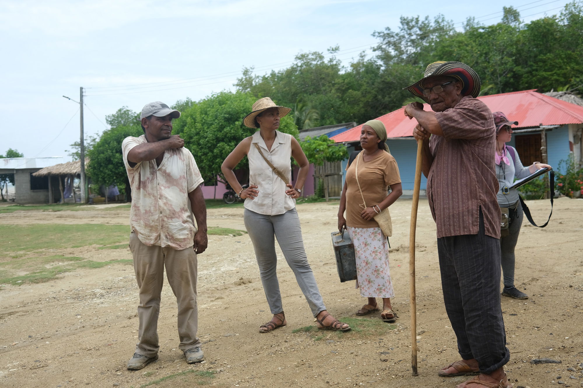 A group of extras stand around on location for Reencuentro