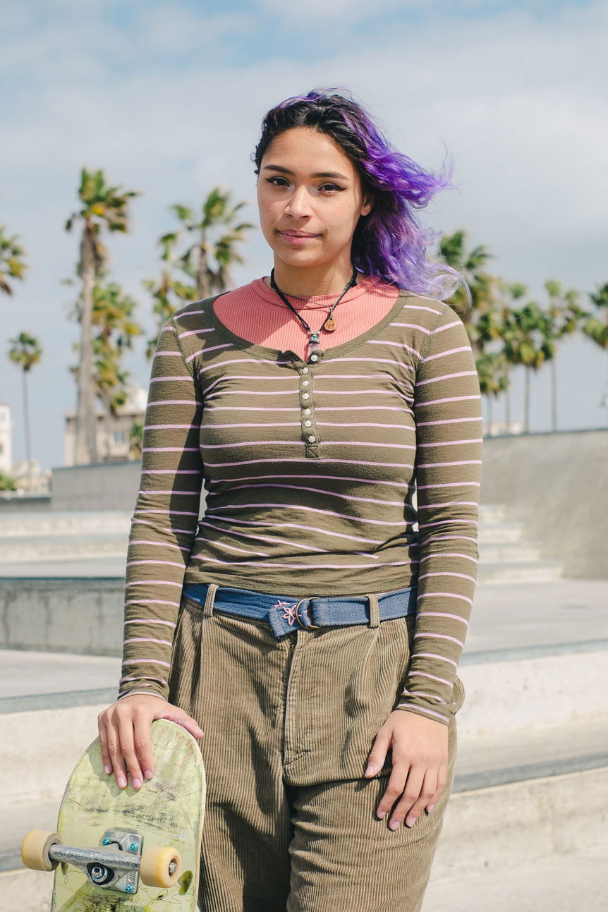 Young woman holding skateboard at California skatepark