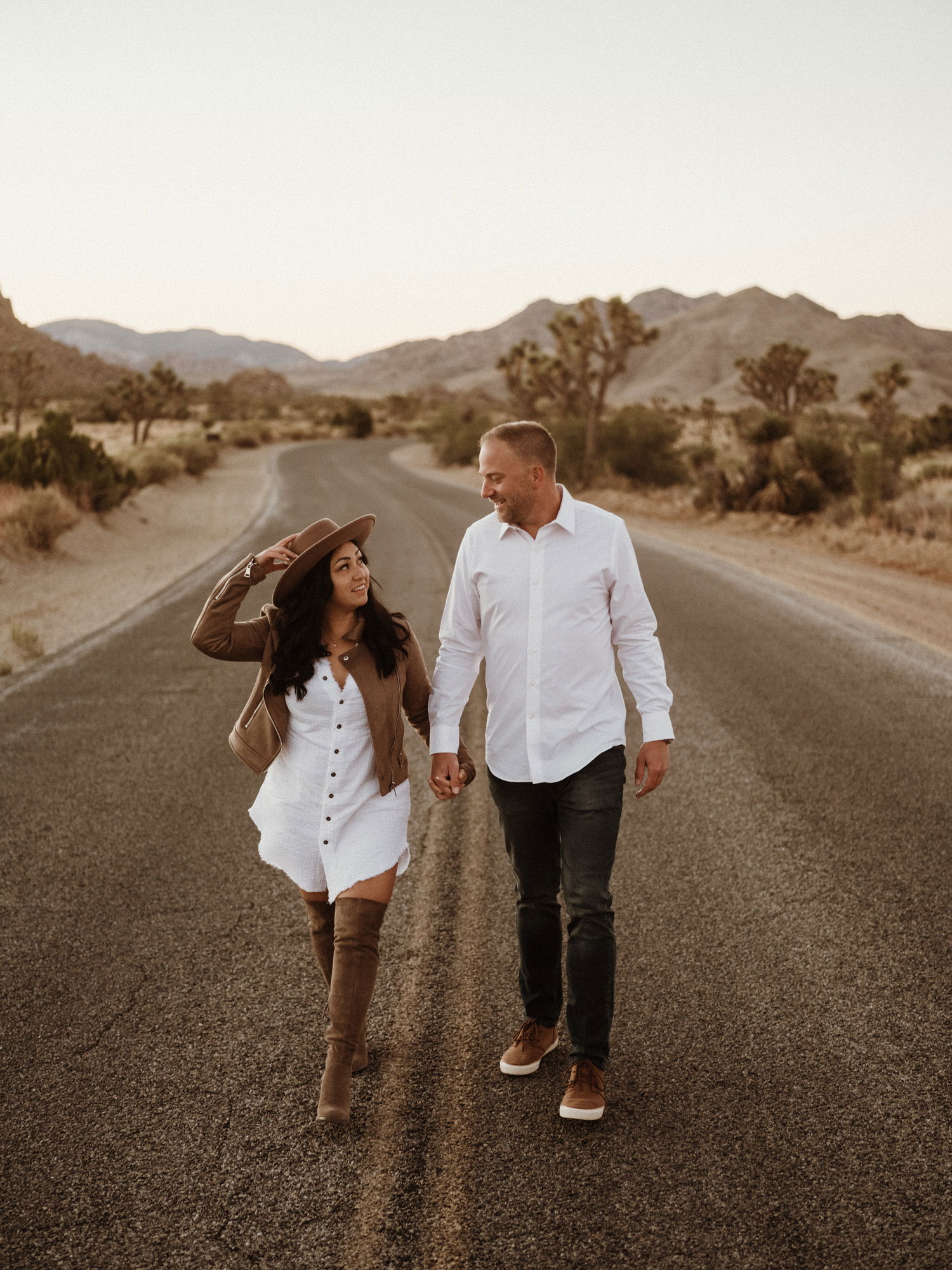 Man and woman holding hands on desert road