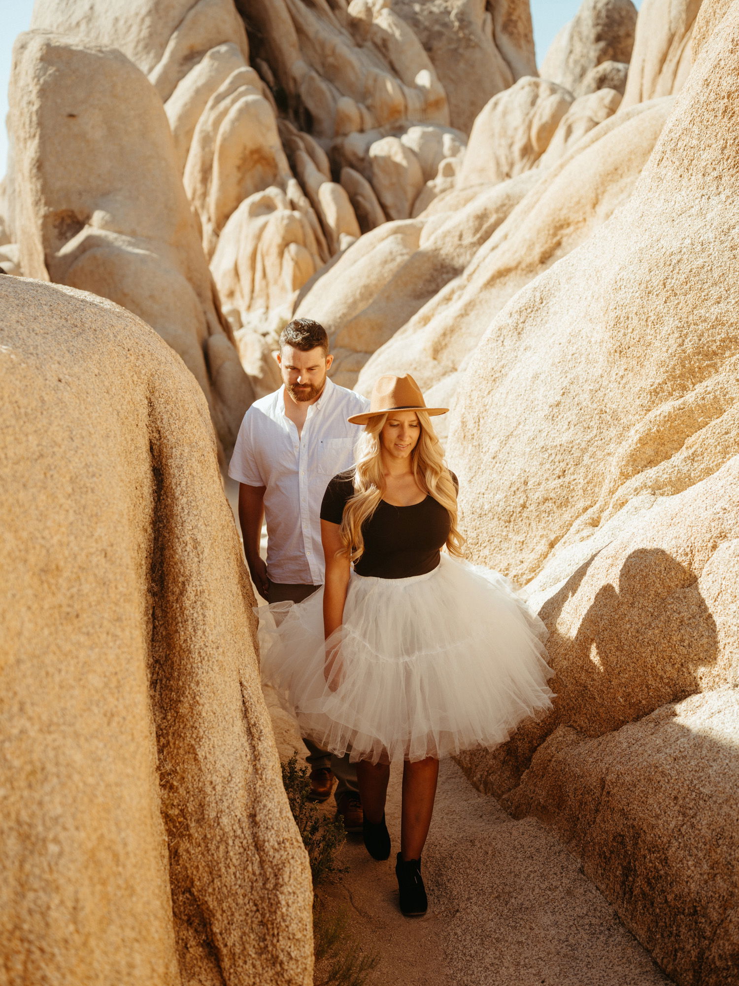 Man and woman holding hands in rocky canyon path