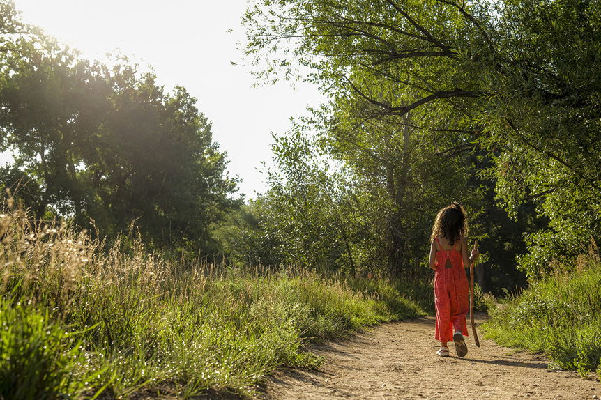 Young African-American woman walking down woodland path