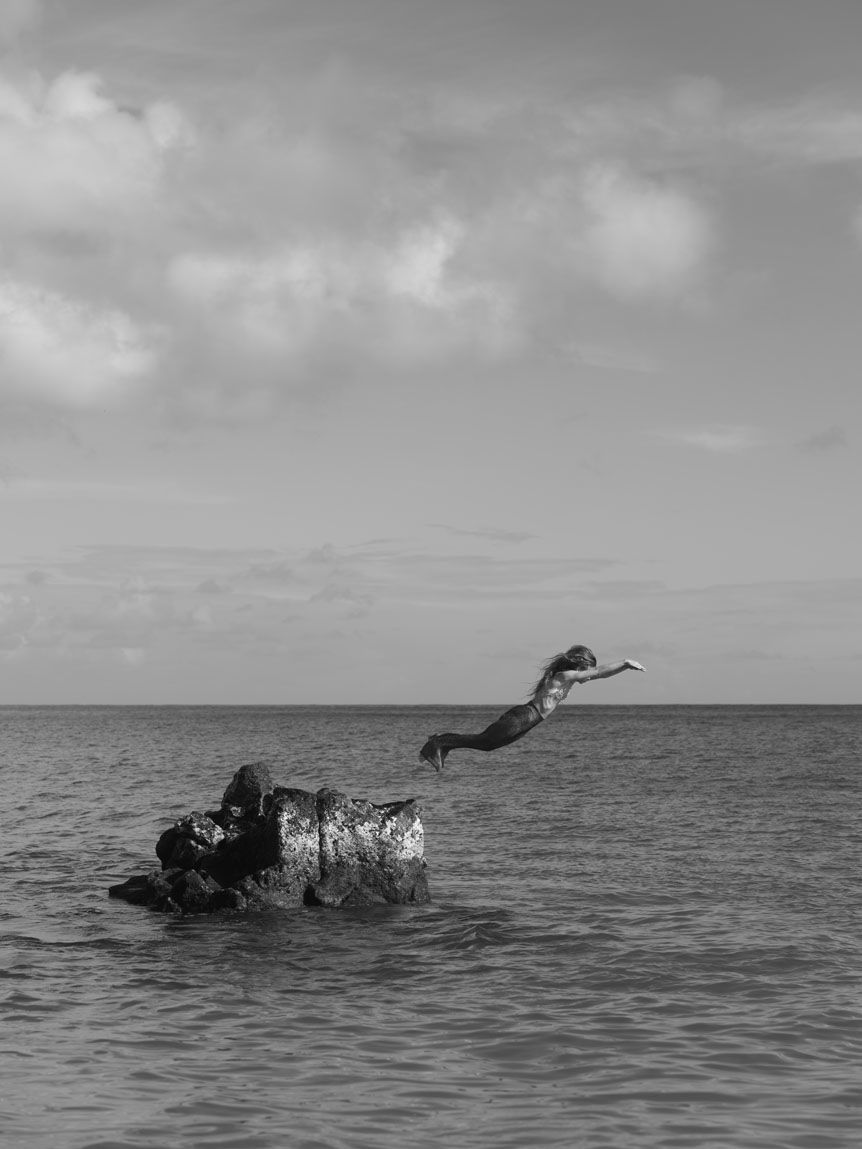 Black and white person jumping into the sea