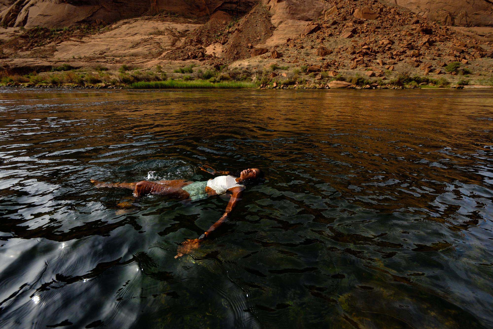 A woman swims through the open-ended pool of a canyon