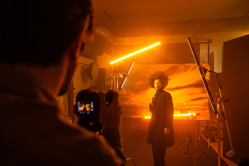 Woman on film set surrounded by orange tube lights