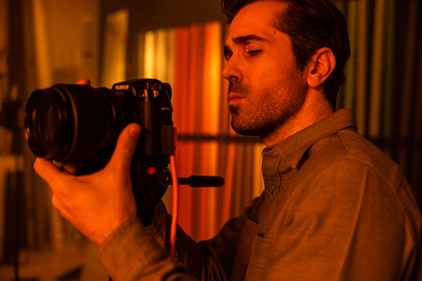 Photographer lining up the shot bathed in orange light