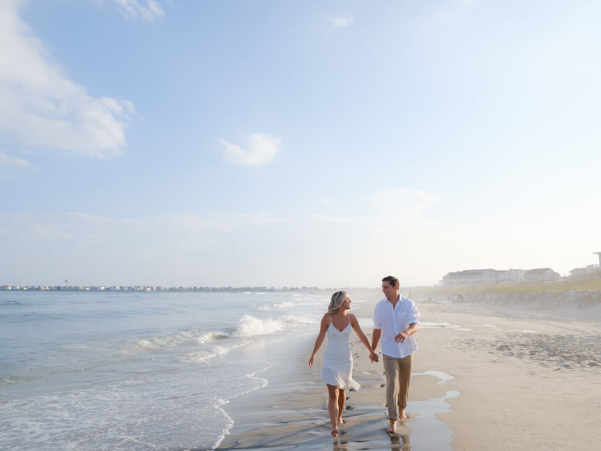 Couple walking together along beach holding hands