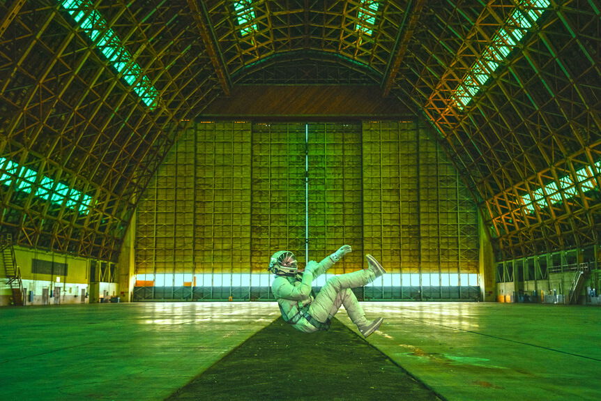Astronaut floating inside blimp hangar