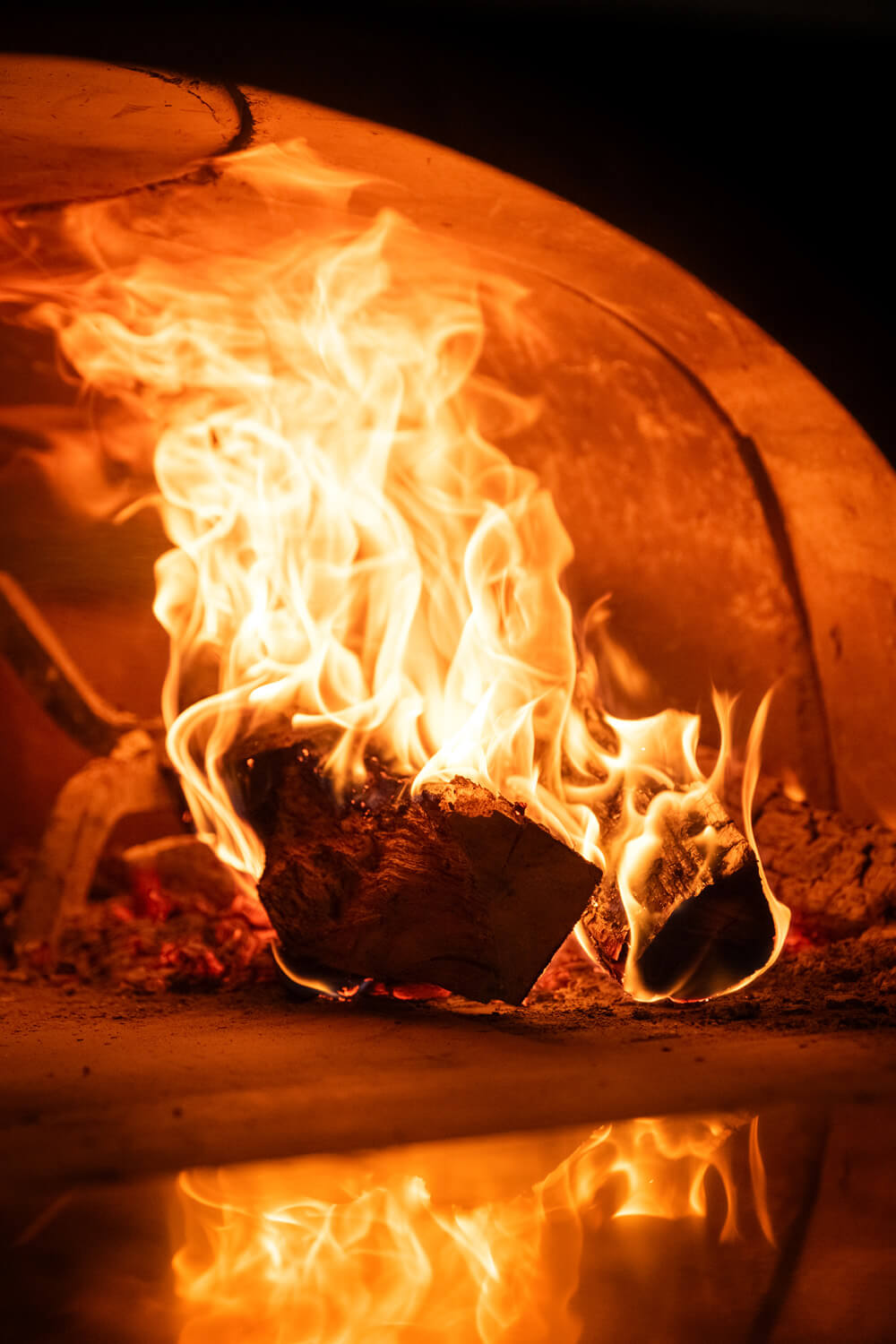 logs burning in pizza oven