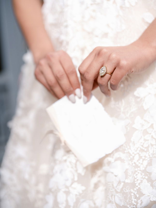 Close up of bride's hands holding white purse
