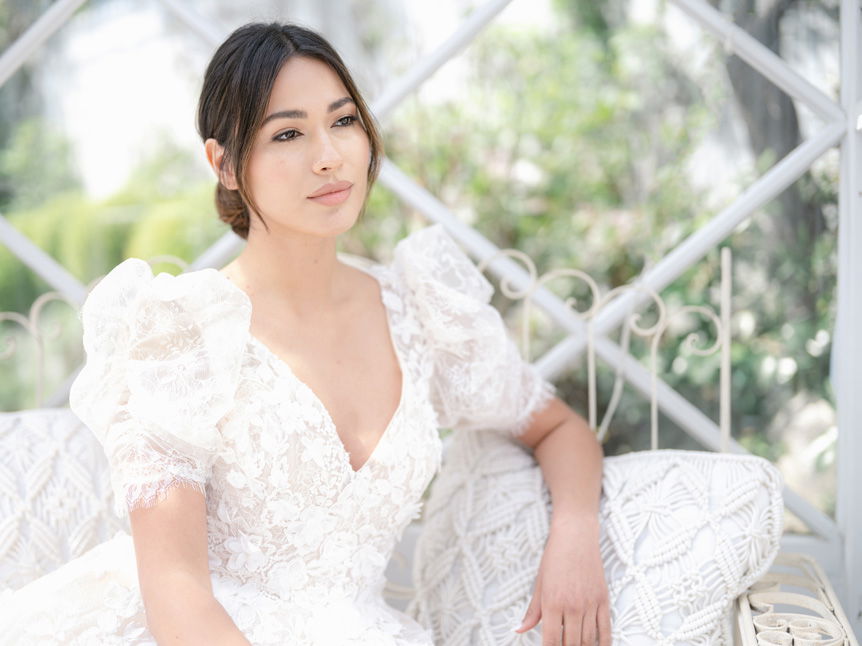 Bride posing for a photo sat down in a wedding dress