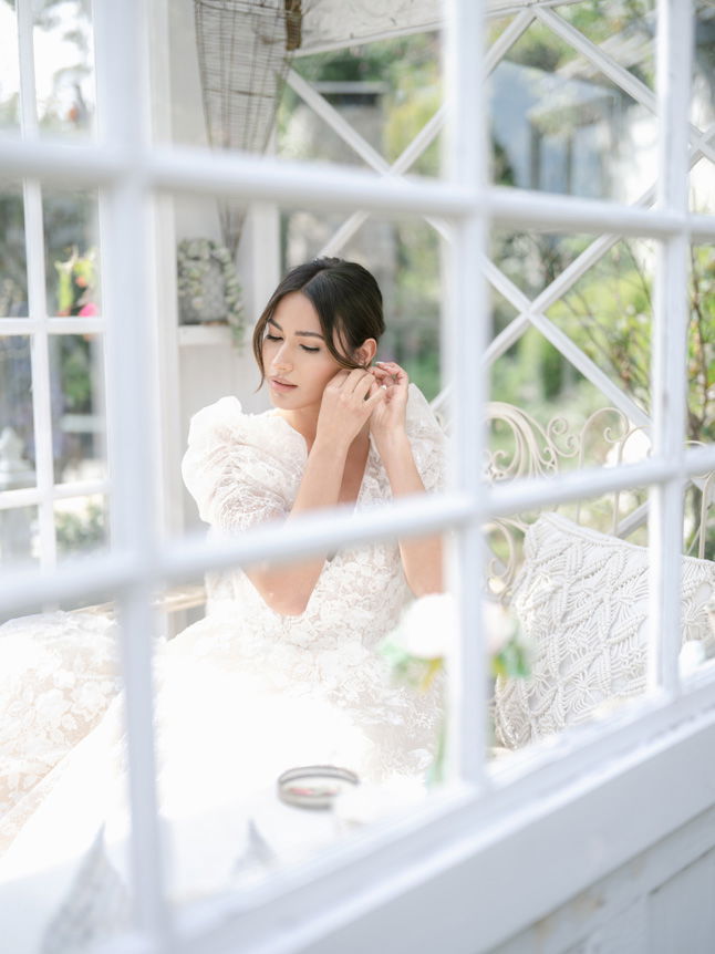 Bride putting on earrings