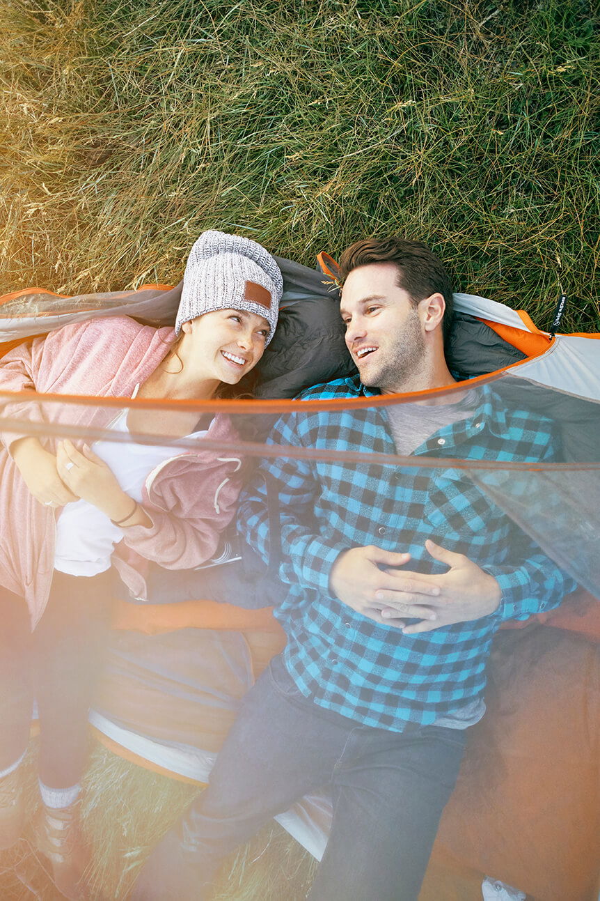 Man and woman lying in orange tent