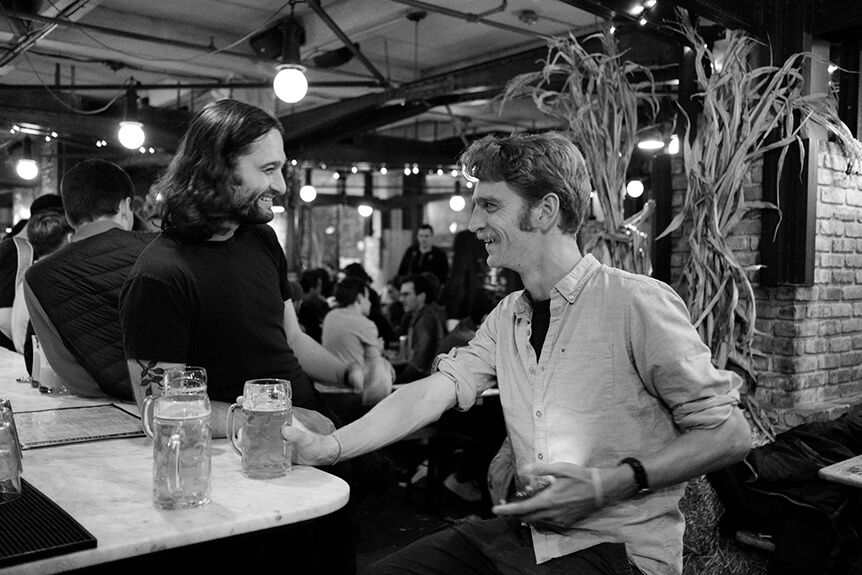 Two men laughing together at a bar