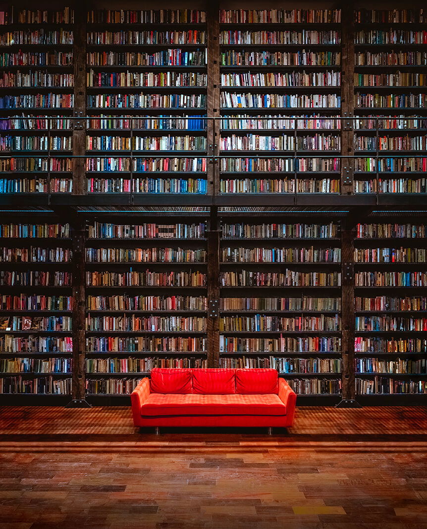 Huge bookcase with red sofa in front