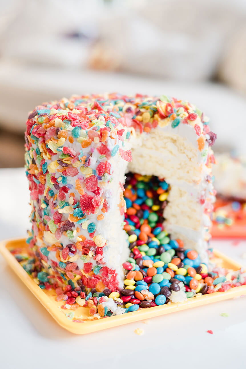 Colourful birthday cake with sweets pouring out of centre